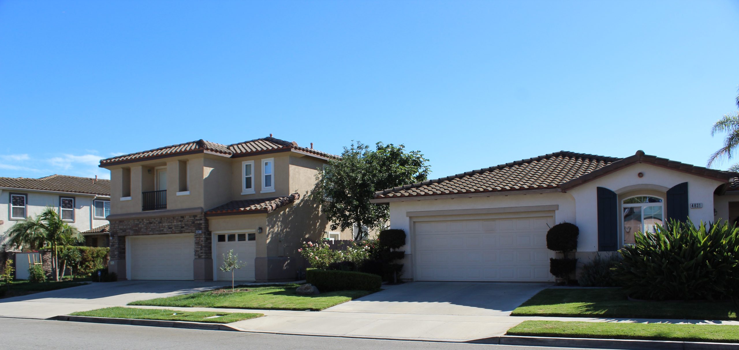 Camarillo suburban homes with well‑kept lawns, American flags, and parked cars on a sunny day, photographed by Diane Schweers.