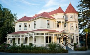 “Historic Camarillo Ranch House, a Queen Anne Victorian built in 1892, surrounded by palm trees and lush grounds.”